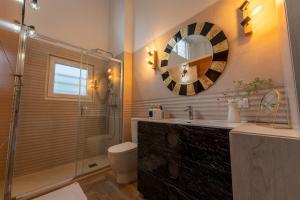 a bathroom with a sink and a shower and a mirror at El loft del sardi in Santander