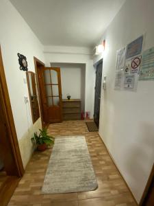 a hallway with a door and a rug at Lemora Apartments 3 in Focşani