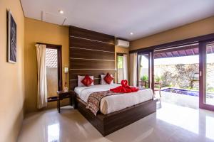 a bedroom with a large bed and a large window at Villa Mandi Resort & spa in Ubud