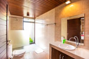 a bathroom with a sink and a toilet and a mirror at Villa Mandi Resort & spa in Ubud +20 photos