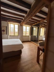 a bedroom with a bed and two windows at Chez collette in Chablis