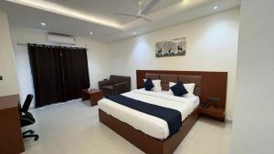 a bedroom with a bed and a chair in it at Hotel Parv Vilas in Behror +5 photos