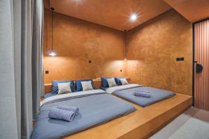 a bedroom with two beds with blue pillows at Redbrick Villa By The Feelas in Bandung +17 photos