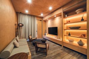 a living room with a couch and a tv at Redbrick Villa By The Feelas in Bandung