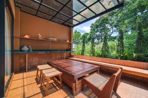 a screened porch with a table and chairs and a window at Redbrick Villa By The Feelas in Bandung