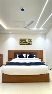 a bedroom with a large bed with blue pillows at Hotel Parv Vilas in Behror