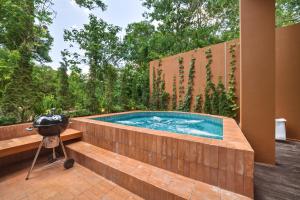 a hot tub on a deck with a grill at Redbrick Villa By The Feelas in Bandung