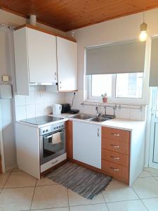 a kitchen with white cabinets and a sink at STUDIO WITH SEA VIEW - KYPARISSIA beach in Kyparissia