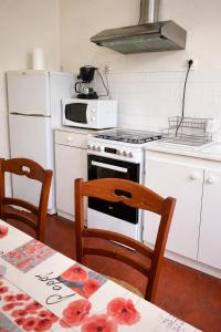 a kitchen with a white stove and a white refrigerator at Maison de la Vallée - proche Zoo Beauval in Angé