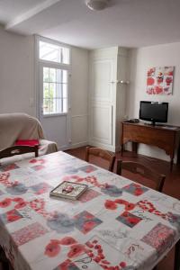 a living room with a table with a blanket on it at Maison de la Vallée - proche Zoo Beauval in Angé