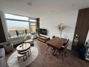 a living room with a table and chairs and a large window at Maisonnette Indysenne in Zandvoort