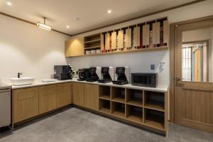 a kitchen with wooden cabinets and a sink at Anook Ryokan Hotel Daejeon Daeheung in Daejeon