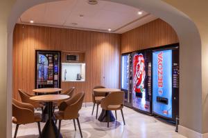 a restaurant with tables and chairs and a vending machine at Hotel Mediodia in Madrid