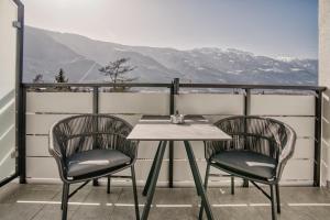 a table and two chairs on a balcony with mountains at byRosi Apartments in Parcines