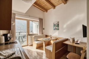 a kitchen and living room with a table and chairs at byRosi Apartments in Parcines