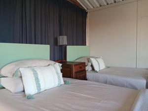 a hotel room with two beds and a night stand at Raapfontein Self-Catering and Camping in Hanover