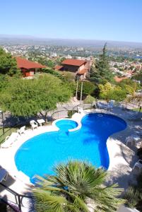 una gran piscina azul con sillas y árboles en Portal de la Montaña en Villa Carlos Paz