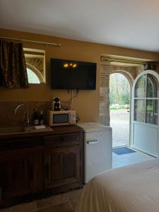 a kitchen with a sink and a microwave at La maison des romans du Château du Sollier - Charme Calme Confort Climatisation - à 5mn du péage de Bourges à la campagne - stationnement privé -Panette Collection in Bourges