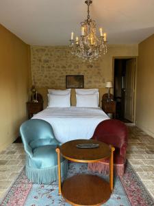 a bedroom with a bed and a couch and a table at La maison des romans du Château du Sollier - Charme Calme Confort Climatisation - à 5mn du péage de Bourges à la campagne - stationnement privé -Panette Collection in Bourges