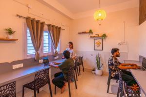 a group of people sitting at a bar in a room at Zostel Guwahati in Guwahati