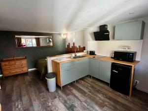 a small kitchen with a sink and a microwave at Appartement confortable et accessible in Pelves