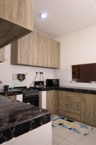 a kitchen with wooden cabinets and a black counter top at C Waves Palm Terraces in Mombasa