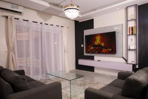 a living room with a couch and a tv on a wall at C Waves Palm Terraces in Mombasa
