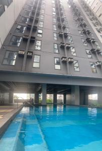 a building with a swimming pool in front of it at Bright Nook in Manila
