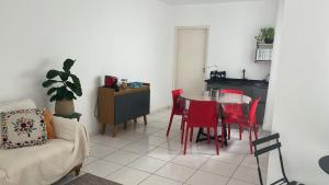 a living room with a table and red chairs at Pousada Sete Colinas in Bragança Paulista