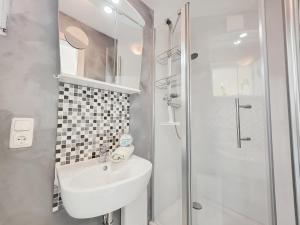 a white bathroom with a sink and a shower at Stettiner Str 6c in Grömitz