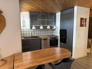 a kitchen with a wooden table and black cabinets at Apartment with mountain view and spa access in Lenzerheide