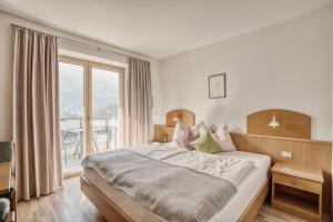 a bedroom with a bed and a large window at byRosi Apartments in Parcines
