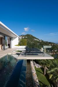 a house with a swimming pool next to a building at Sukkho Samui Estates in Chaweng Noi Beach