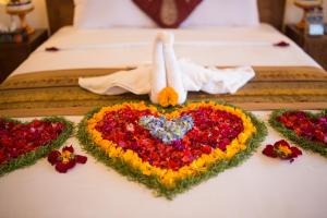 a bed with a heart made out of flowers on it at Villa Mandi Resort & spa in Ubud