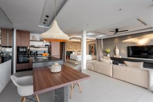 a kitchen and living room with a table and a couch at Sukkho Samui Estates in Chaweng Noi Beach