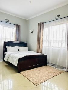 a bedroom with a large bed and two windows at Olive homes in Nkunjila