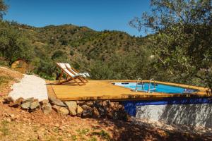 a deck with a chair and a swimming pool at Finca la montaña roja in Almogía