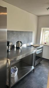 a kitchen with a stainless steel counter with a tea kettle at Ferienwohnung2 Renate Strohhöfer in Hirschaid