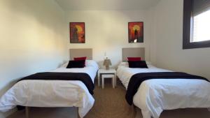 two twin beds in a room with a table at Casa Xandra in Tabernas