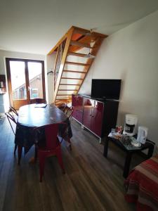 a living room with a table and a television at Les racines Bohèmes in Avèze