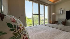 a bedroom with a large bed with a large window at 小k咖啡B&B 寵物友善 咖啡廳民宿 in Sanxing
