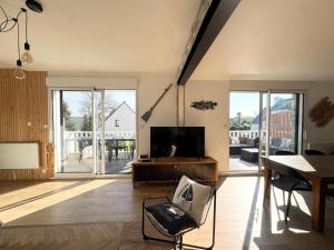 a living room with a flat screen tv and a table at Ti-annez mor in Bénodet