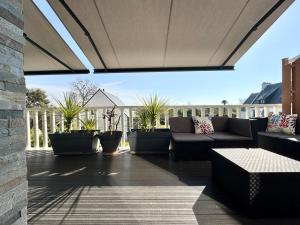 an outdoor patio with couches and potted plants at Ti-annez mor in Bénodet