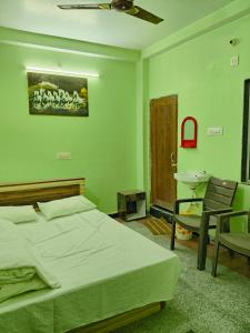 a green bedroom with a bed and a sink at Rupali Guest House in Patna
