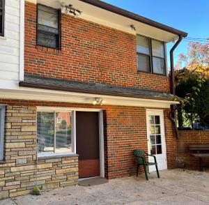 a brick house with a green chair in front of it at Flower Avenue Hosting -Two DB Beds & Shower - Ground Floor Bedroom 1 Person 66 Night, 2 persons 122 - 3rd & 4th add 52 each in Silver Spring