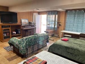 a living room with two beds and a flat screen tv at Flower Avenue Hosting -Two DB Beds & Shower - Ground Floor Bedroom 1 Person 66 Night, 2 persons 122 - 3rd & 4th add 52 each in Silver Spring