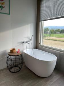 a white bath tub in a bathroom with a window at 小k咖啡B&B 寵物友善 咖啡廳民宿 in Sanxing +21 photos