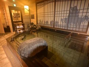 a swimming pool with a tub in a building at Dormy Inn Hakata Gion in Fukuoka