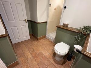 a bathroom with a toilet and a door at True Lovers Knot, Tarrant Keyneston in Tarrant Keynston