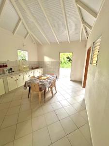 a kitchen with a table and chairs in a room at Séjour Caraïbe in Pointe-Noire